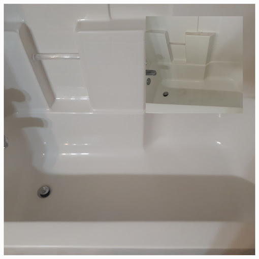 A white bath tub sitting under a bathroom mirror