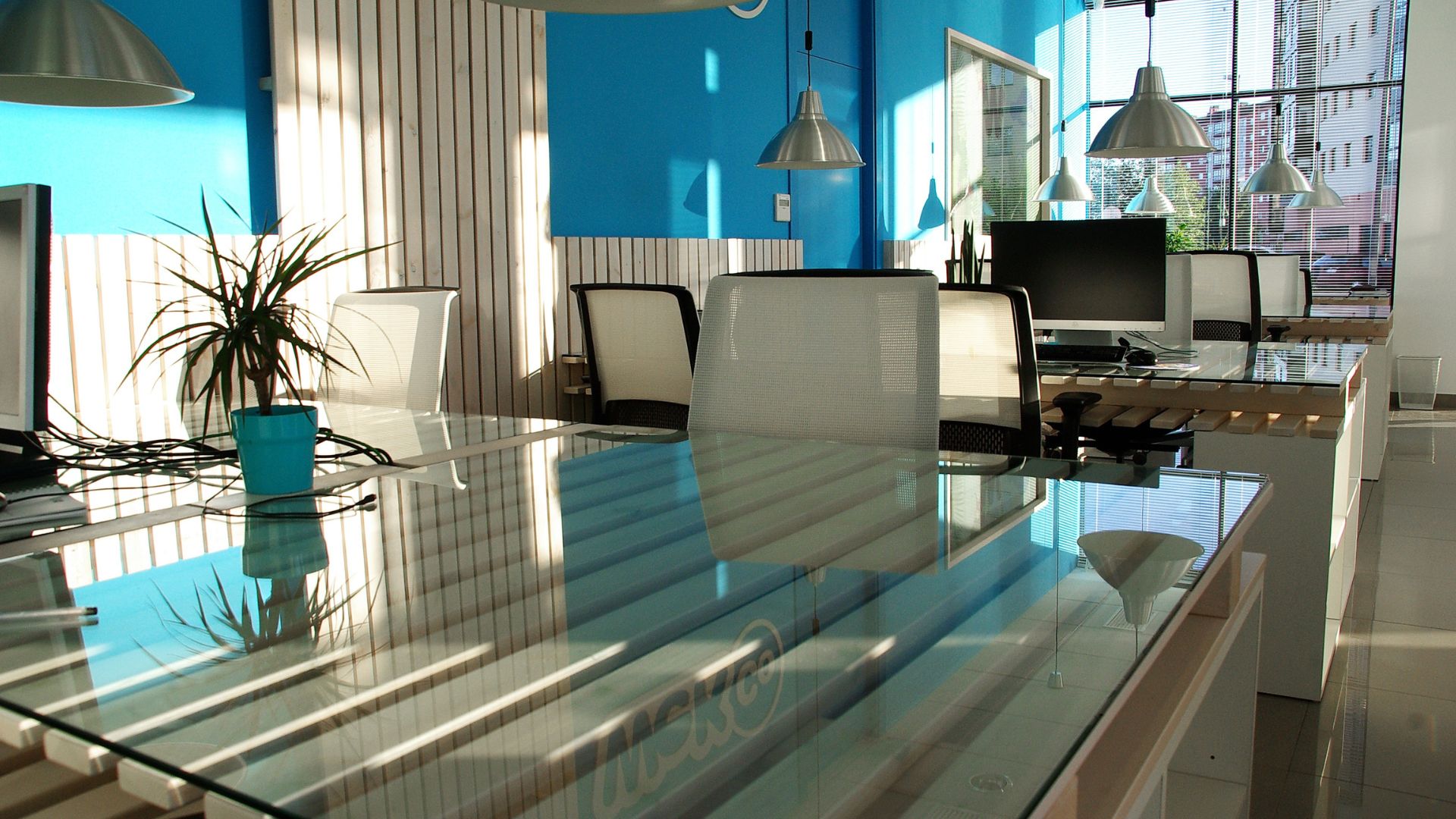 A glass table with chairs and a computer on it